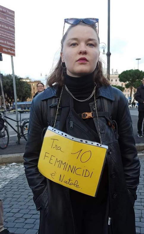 Persona al Corteo del 25 novembre, con un cartello: "Tra 10 femminicidi è Natale"